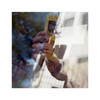 color film fine art photograph with two layered images of a hand holding a yellow cell phone